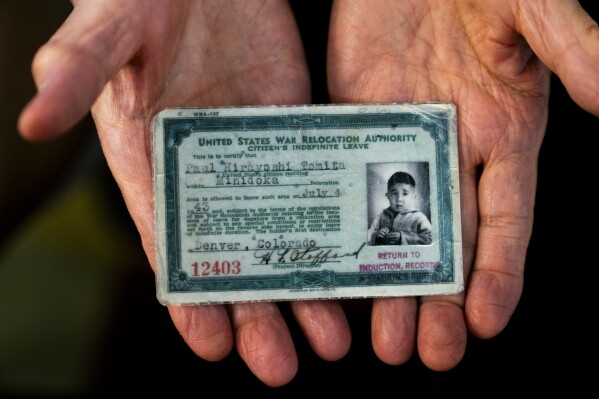 Paul Tomita displays a copy of his exit card granted to him on July 4, 1943, as the family was allowed to leave after Tomita's father signed loyalty documents and passed security clearance to work for the Office of Secret Service, which later became the CIA, Friday, July 7, 2023, in Twin Falls, Idaho. (AP Photo/Lindsey Wasson)