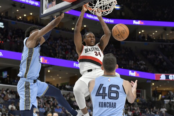 Portland Trail Blazers forward Jabari Walker (34) dunks between Memphis Grizzlies forward GG Jackson II, left, and guard John Konchar (46) in the second half of an NBA basketball game Saturday, March 2, 2024, in Memphis, Tenn. (AP Photo/Brandon Dill)