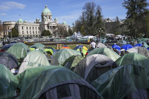Students and former paramilitary fighters, loyal to President Aleksandar Vucic, are camping outside the presidency building in Belgrade, Serbia, Thursday, March 13, 2025, fueling fears of violent incidents during a major anti-corruption rally this weekend. (AP Photo/Darko Vojinovic)