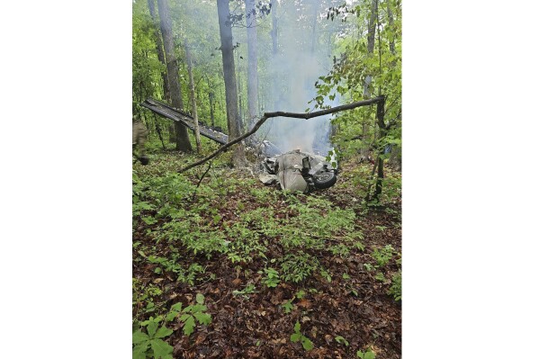 The wreckage of a small aircraft smolders in a woods in Fluvanna County, Va., Sunday, May 5, 2024. Two people were killed when the plane headed for South Carolina crashed in Virginia, according to authorities. (Virginia State Police via AP)