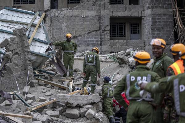 Personnel from the Kenya Defence Forces disaster response unit examine the scene of a building collapse in the Kasarani neighborhood of Nairobi, Kenya Tuesday, Nov. 15, 2022. Workers at the multi-storey residential building that was under construction are feared trapped in the rubble and rescue operations have begun, but there was no immediate official word on any casualties. (AP Photo/Ben Curtis)