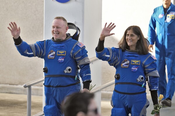 NASA astronauts Butch Wilmore, left, and Suni Williams wave as they leave the operations and checkout building for a trip to launch pad at Space Launch Complex 41 Wednesday, June 5, 2024, in Cape Canaveral, Fla. The two astronauts are scheduled to liftoff later today on the Boeing Starliner capsule for a trip to the international space station. . (AP Photo/Chris O'Meara)