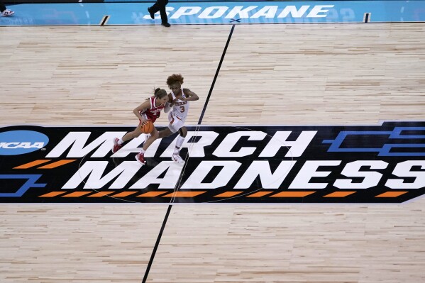 FILE - Ohio State guard Jacy Sheldon, left, drives past Texas guard Rori Harmon, right, during the first half of a college basketball game in the Sweet 16 round of the NCAA tournament at Spokane Arena on Friday, March 25, 2022, in Spokane, Wash. Twelve teams. Nine games. Four days. For a major college hoops fan who wants a centralized location to watch as much of the NCAA Tournament in person as possible, there might not be a better place than Spokane.(AP Photo/Ted S. Warren, File)