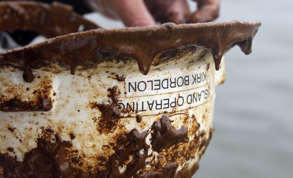 FILE - A hard hat covered in oil is shown after being found in the waters off of Chandeleur Sound, La., May 3, 2010. (AP Photo/Alex Brandon, File)