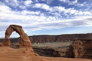 FILE - Delicate Arch is seen at Arches National Park on April 25, 2021, near Moab, Utah. Record visitation and long lines at Arches National Park in Utah are reviving a push for a reservation system. KUER reports Arches is on track to have its busiest year ever, and that increase in visitation has caused the park to close its gates over 80 times so far in 2021. (AP Photo/Lindsay Whitehurst, File)