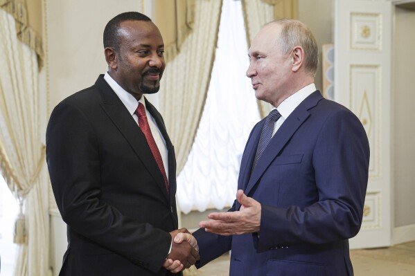 Russian President Vladimir Putin, right, and Ethiopian Prime Minister Abiy Ahmed shake hands during their meeting on the eve of the Russia Africa Summit in St. Petersburg, Russia, Wednesday, July 26, 2023. (TASS News Agency Host Pool Photo via AP, File)