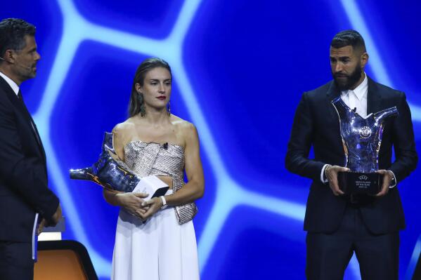 Barcelona's Alexia Putellas, center, and Real Madrid's Karim Benzema, right, hold their trophies as women's and men's players of the year during the soccer Champions League draw ceremony in Istanbul, Turkey, Thursday, Aug. 25, 2022. (AP Photo/Emrah Gurel)