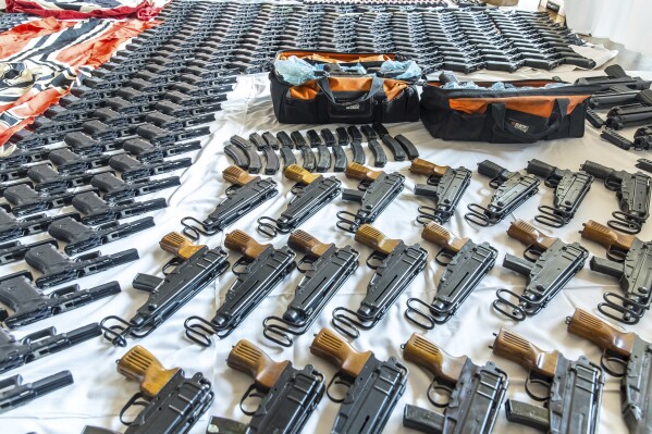 This picture provided by the Austrian Interior Ministry on Thursday, June 29, 2023 shows secured weapons, objects and ammunitions. Austrian authorities have seized large amounts of drugs and weapons in a raid on a far-right biker gang tied to organized crime. Public broadcaster ORF reported Thursday that police searched properties in Upper Austria and detained 10 people on suspicion of breaching firearms, narcotics and extremism laws. (BMI/Gerd Pachauer via AP)
