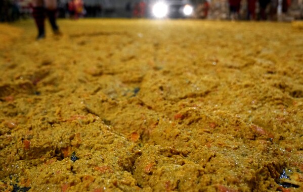 Smashed oranges are scattered on the ground following the "Battle of the Oranges" where people pelt each other with oranges as part of Carnival celebrations in the northern Italian Piedmont town of Ivrea, Italy, Tuesday, Feb. 13, 2024. (AP Photo/Antonio Calanni)