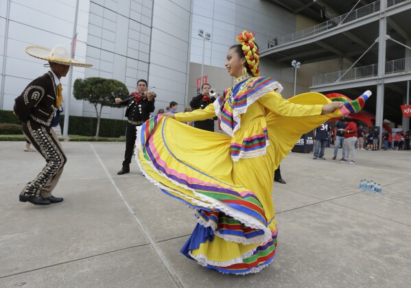 FILE - Members of a Ballet Folklorico perform as part of NFL Hispanic Heritage Month prior to an NFL football game, Sept. 28, 2014, in Houston. Hispanic history and culture take center stage across the U.S. for National Hispanic Heritage Month. The celebration recognizes contributions made by Hispanic Americans, the fastest-growing racial or ethnic minority according to the Census, and with a U.S. population of over 63 million people, there will be a plethora of Hispanic Heritage Month celebrations all over the country starting Friday, Sept. 15, 2023. (AP Photo/Patric Schneider, File)
