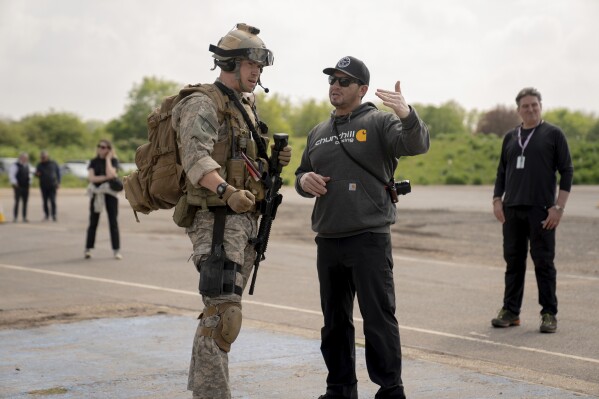 This image released by A24 shows Will Poulter, left, and Ray Mendoza on the set of 