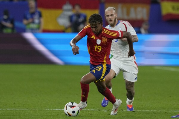 Spain's Lamine Yamal, left, runs with the ball past Italy's Federico Dimarco during a Group B match between Spain and Italy at the Euro 2024 soccer tournament in Gelsenkirchen, Germany, Thursday, June 20, 2024. (AP Photo/Frank Augstein)