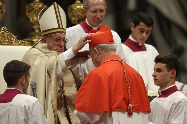 New Cardinal Kevin Joseph Farrell, prefect of the Vatican dicastery for laity, family and life, receives the red three-cornered biretta hat from Pope Francis inside St. Peter's Basilica at the Vatican on Nov. 19, 2016. (AP Photo/Gregorio Borgia, File)