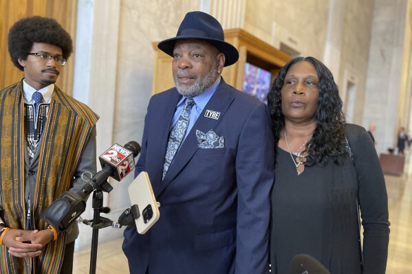 Mother RowVaughn Wells, right, and stepfather Rodney Wells, center, speak at the Tennessee Capitol on Thursday, March 14, 2024 in opposition to a bill that would rescind some policing changes made in Memphis after their son, Tyre Nichols, died following a police beating in January 2023. Rep. Justin Pearson, left, introduced them at the news conference. (AP Photo/Jonathan Mattise)