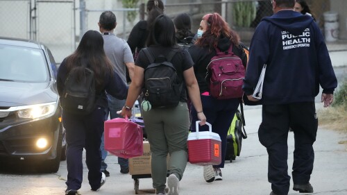 लॉस एंजिल्स काउंटी के सार्वजनिक स्वास्थ्य आपातकालीन प्रतिक्रिया अधिकारी बुधवार, 14 जून, 2023 को लॉस एंजिल्स के चाइनाटाउन क्षेत्र में नए आए अप्रवासियों का आकलन करने के बाद सेंट एंथोनी के क्रोएशियाई कैथोलिक चर्च से चले गए।  टेक्सास के गवर्नर ग्रेग एबॉट ने कहा कि अप्रवासियों को लॉस एंजिल्स भेजा गया क्योंकि कैलिफोर्निया ने खुद को घोषित कर दिया था। "अभ्यारण्य" आप्रवासियों के लिए.  (एपी फोटो/डेमियन डोवेर्गेन्स)