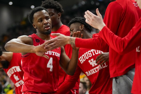 Houston guard L.J. Cryer (4) is greeted at the bench by teammates during the first half of an NCAA college basketball game against Baylor, Saturday, Feb. 24, 2024 in Waco, Texas. (AP Photo/Julio Cortez)