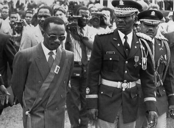 President Jean-Bertrand Aristide walks with Haitian Armed Forces Chief of Staff General Herard Abraham while inspecting the troops at the Presidential Palace after his inauguration ceremony in Port-au-Prince, Feb. 8, 1991. (AP Photo/Michael Stravato)