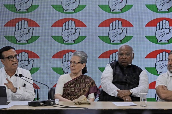 Congress party treasurer Ajay Maken, left, speaks and displays the notice from Indian taxation authority as party president Mallikarjun Kharge, second right, and senior party leaders Sonia Gandhi, second left, and Rahul Gandhi listen during a press conference at their party headquarters in New Delhi, India, Thursday, March 21, 2024. (AP Photo/Manish Swarup)