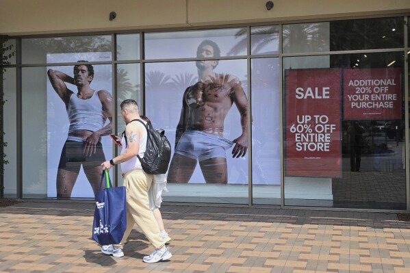 Shoppers walks past a Calvin Klein store at Citadel Outlets in Commerce, Calif., April 14, 2025. (AP PhotoDamian Dovarganes, file)