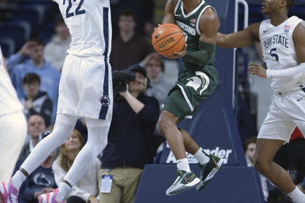 Michigan State's Tyson Walker, center, drives between Penn State's Qudus Wahab (22) and Jameel Brown (5) during the first half of an NCAA college basketball game Wednesday, Feb. 14, 2024, in State College, Pa. (AP Photo/Gary M. Baranec)