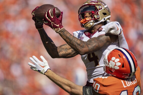 Florida State wide receiver Keon Coleman (4) catches a pass for a touchdown while covered by Clemson cornerback Jeadyn Lukus (10) during overtime in an NCAA college football game Saturday, Sept. 23, 2023, in Clemson, S.C. (AP Photo/Jacob Kupferman)