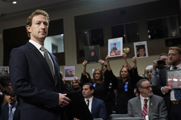With people holding photos of their loved ones in the audience, Meta CEO Mark Zuckerberg arrives to testify before a Senate Judiciary Committee hearing on Capitol Hill in Washington, Wednesday, Jan. 31, 2024, to discuss child safety. (AP Photo/Susan Walsh)