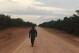 FILE - A man walks down an unpaved stretch of highway BR-319 in the Brazilian Amazon between the cities of Manaus and Porto Velho on Aug. 10, 2018. A Brazilian federal court on July 24, 2024, halted progress on the project paving this dirt highway that connects the major city of Manaus with populous regions, citing the likelihood it will contribute to climate change. (ĢӰԺ Photo/Fabiano Maisonnave, File)