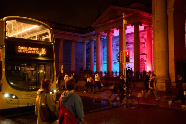 People walk the streets in Dublin, Ireland, Wednesday, Oct. 16, 2024. (AP Photo/Bram Janssen) 


