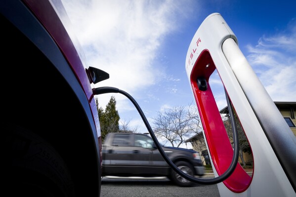 A Tesla charger is operates Monday, March 4, 2024, in Charlotte, N.C. In campaigns for Congress and for governor around the country, candidates are talking about how green the grid should be. (AP Photo/Chris Carlson)