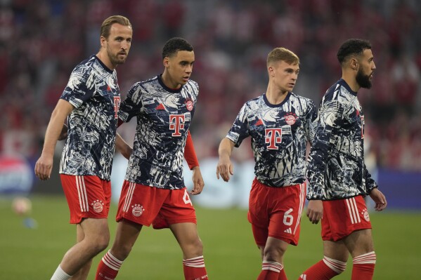 Bayern's Harry Kane, left, Bayern's Jamal Musiala, second left, Bayern's Noussair Mazraoui, right, and Bayern's Joshua Kimmich warm up prior to the Champions League semifinal first leg soccer match between Bayern Munich and Real Madrid at the Allianz Arena in Munich, Germany, Tuesday, April 30, 2024. (AP Photo/Matthias Schrader)