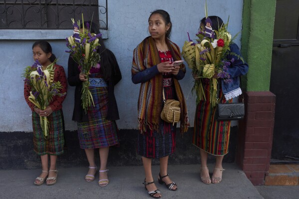 Women hold palm bouquets waiting for a Palm Sunday procession in the Kaqchikel indigenous community of San Pedro Sacatepequez, Guatemala, Sunday, April 13, 2025. (AP Photo/Moises Castillo)