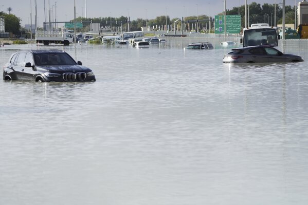 Vehicles sit abandoned in floodwater covering a major road in Dubai, United Arab Emirates, Wednesday, April 17, 2024. Heavy thunderstorms lashed the United Arab Emirates on Tuesday, dumping over a year and a half's worth of rain on the desert city-state of Dubai in the span of hours as it flooded out portions of major highways and its international airport. (AP Photo/Jon Gambrell)