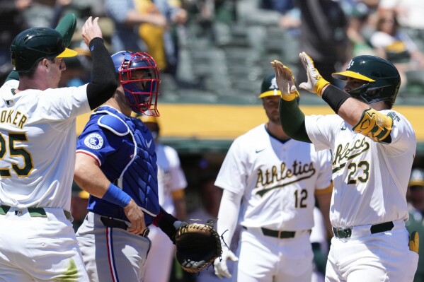 Oakland Athletics' Shea Langeliers, right, celebrates with Brent Rooker, left, after hitting a two-run home run against the Texas Rangers during the second inning in the first baseball game of a doubleheader Wednesday, May 8, 2024, in Oakland, Calif. (AP Photo/Godofredo A. Vásquez)