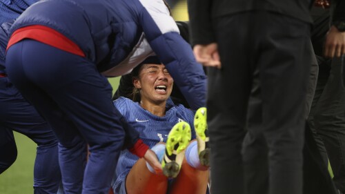 France's Selma Bacha grimaces as she is lifted onto a stretch after an injury during their friendly soccer match against Australia ahead of the Women's World Cup in Melbourne, Friday, July 14, 2023. (AP Photo/Hamish Blair)