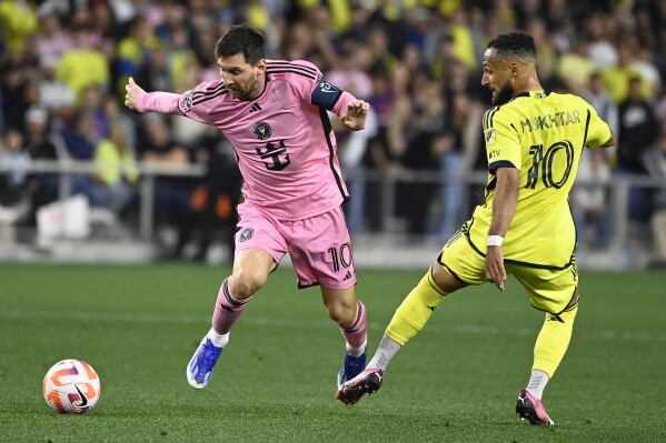 Inter Miami forward Lionel Messi (10) kicks the ball away from from Nashville SC midfielder Hany Mukhtar (10) during the first half of a CONCACAF Champions Cup tournament soccer match Thursday, March 7, 2024, in Nashville, Tenn. (AP Photo/Mark Zaleski)