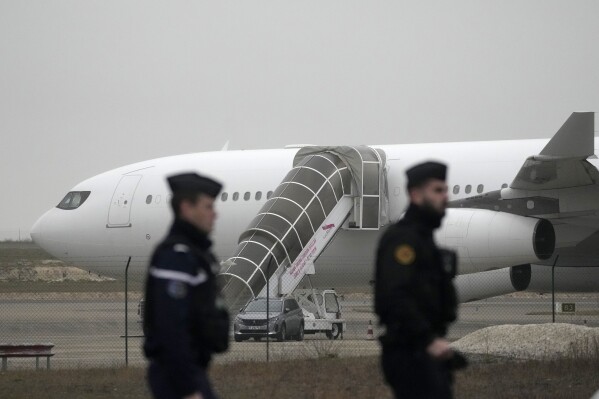 A gendarmerie patrol with a plane stopped by police for possibly carrying human trafficking victims at Vally Airport in Vatry, eastern France, Monday, December 25, 2023.  (AP Photo/Christophe Ena)