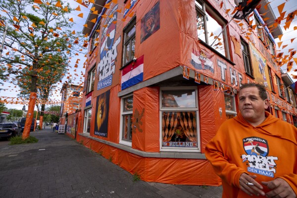 Macho Vink, a 35-year-old truck driver volunteered to decorate Marktweg street with orange tarp, orange bunting, and Dutch national flags in The Hague, Netherlands, Thursday June 13, 2024, one day ahead of the start of the Euro 2024 Soccer Championship. The Marktweg is one of several streets in the Netherlands that get an all-encompassing orange facelift during European Championships and World Cups when the national team, known as Oranje after the Dutch royal family and the color of their shirts, are playing. (AP Photo/Peter Dejong)