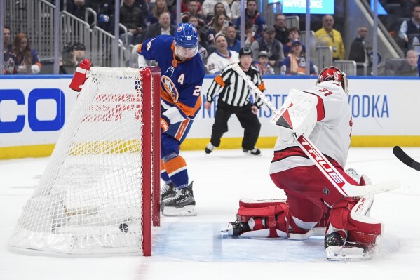 New York Islanders' Brock Nelson, left, scores against Carolina Hurricanes goaltender Frederik Andersen during the second period of Game 3 of an NHL hockey Stanley Cup first-round playoff series Thursday, April 25, 2024, in Elmont, N.Y. (AP Photo/Frank Franklin II)