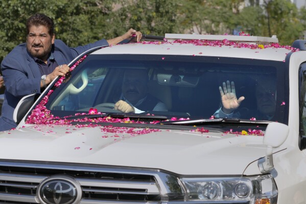 Pakistan's former Prime Minister Nawaz Sharif, right in vehicle, waves to his supporters as he leaves after appearing in a court in Islamabad, Pakistan, Tuesday, Oct. 24, 2023. Sharif returned to Pakistan on last Saturday, ending his four years of self-imposed exile in London. Sharif is facing multiple legal challenges. A Pakistani federal court on last Thursday granted him bail until Oct. 24, giving him protection from arrest until then. (AP Photo/Anjum Naveed)