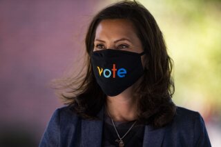 Michigan Gov. Gretchen Whitmer wears a mask with the word "vote" displayed on the front during a roundtable discussion on healthcare, Wednesday Oct. 7, 2020, in Kalamazoo, Mich. The arrest of a group of anti-government vigilantes in a kidnapping plot against Michigan Gov. Gretchen Whitmer presents a new twist in the 2020 political fight for the battleground state. (Nicole Hester/Ann Arbor News via AP)/