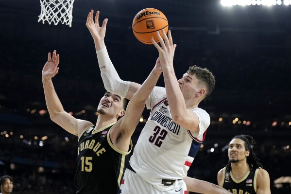UConn center Donovan Clingan (32) and Purdue center Zach Edey battle for the rebound during the second half of the NCAA college Final Four championship basketball game, Monday, April 8, 2024, in Glendale, Ariz. (AP Photo/Brynn Anderson)