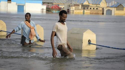 Männer laufen am Montag, 15. Mai 2023, auf einer Straße in der Stadt Beledweyne in Somalia durch Überschwemmungen. Schätzungen des UN-Büros für die Koordinierung humanitärer Angelegenheiten zufolge sind seit Mitte März 460.000 Menschen von Überschwemmungen aufgrund heftiger Regenfälle betroffen.  (AP-Foto)