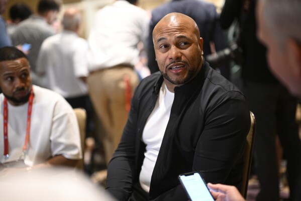 Las Vegas Raiders head coach Antonio Pierce, center, talks with reporters during an AFC coaches availability at the NFL owners meetings, Monday, March 25, 2024, in Orlando, Fla. (AP Photo/Phelan M. Ebenhack)
