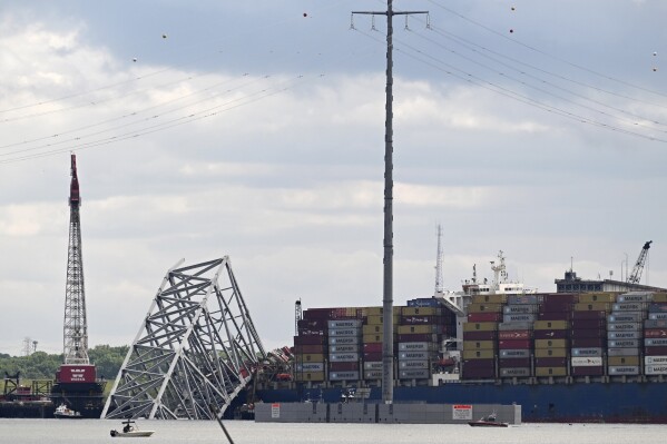Remnants of the collapsed Francis Scott Key Bridge and the cargo ship Dali are seen, Sunday, May 12, 2024, in Baltimore. For safety reasons, officials postponed a controlled demolition, which was planned for Sunday, to break down the largest remaining span of the collapsed bridge. The bridge came crashing down under the impact of the massive container ship on March 26. (AP Photo/Steve Ruark)