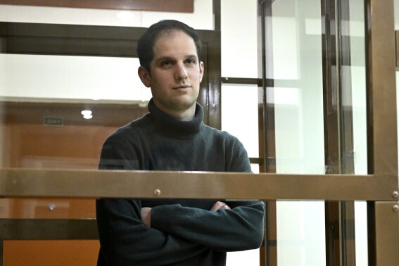 FILE - Wall Street Journal reporter Evan Gershkovich stands in a glass cage in a courtroom at the Moscow City Court, in Moscow, Russia, on Dec. 14, 2023. A lawyer for The Wall Street Journal said Thursday, March 21, 2024, that Russia must face consequences for its detention of Gershkovich, one of the newspaper's reporters. Gershkovich was arrested on March 29, 2023, on espionage charges, which he and the newspaper deny. (AP Photo/Dmitry Serebryakov, File)