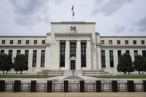 FILE - An American flag flies over the Federal Reserve building on May 4, 2021, in Washington. The Federal Reserve has launched their instant payment service, FedNow, which allows banks and credit unions to sign up to send real-time payments between them. (AP Photo/Patrick Semansky, File)