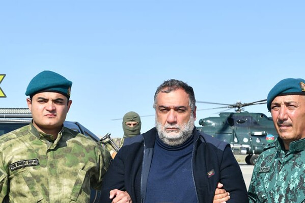 In this photo released by Azerbaijan's border guard service on Wednesday, Sept. 27, 2023, Azerbaijan's border guard officers pose with detained Ruben Vardanyan, center, in Nagorno-Karabakh. Azerbaijan says it has detained the former head of Nagorno-Karabakh's separatist government as he tried to cross into Armenia following Azerbaijan's 24-hour blitz last week to reclaim control of the enclave. The arrest of Ruben Vardanyan was announced by Azerbaijan's border guard service. (Azerbaijan's border guard service via AP)