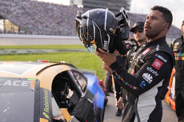 Bubba Wallace puts on his helmet before a NASCAR Cup Series auto race Sunday, June 1, 2025, in Lebanon, Tenn. (AP Photo/George Walker IV)