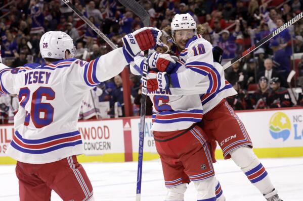 New York Rangers left wing Artemi Panarin (10) celebrates during the third period with left wing Jimmy Vesey (26) and center Vincent Trocheck (16) after his second goal of an NHL hockey game against the Carolina Hurricanes, Saturday, Feb. 11, 2023, in Raleigh, N.C. (AP Photo/Chris Seward)