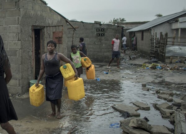 
              People return to Praia Nova Village, one of the most affected neighbourhoods following a cyclone in the coastal city of Beira, Mozambique, Sunday March 17, 2019. Families are returning to the vulnerable shanty town following cyclone high winds and rain.  More than 1,000 people are feared dead in Mozambique four days after a cyclone slammed into the southern African country. (Josh Estey/CARE via AP)
            